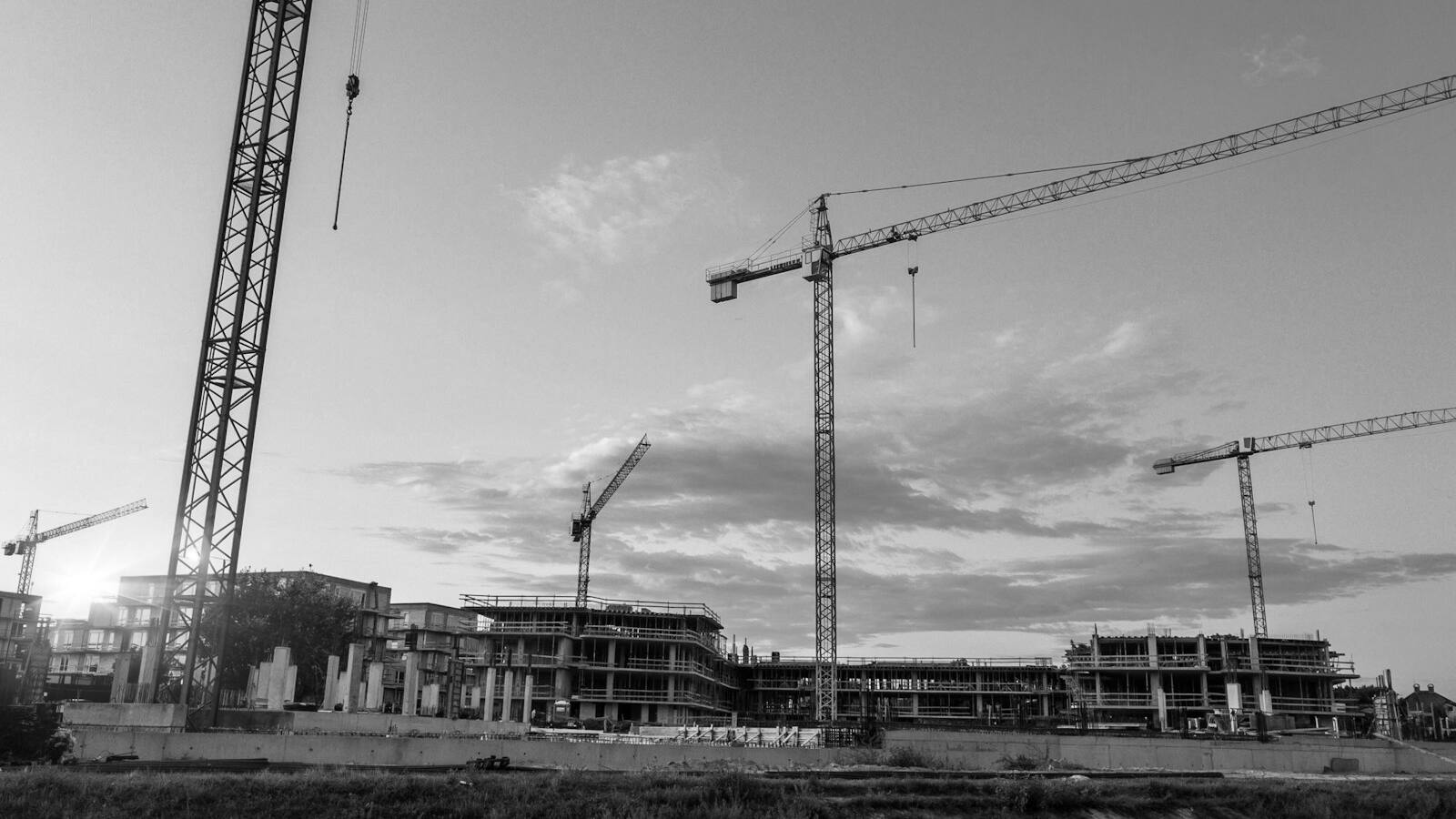 Tower cranes over a construction site at dusk